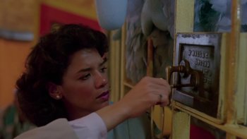 Movie still from “Follow That Bird” (1985), directed by Ken Kwapis – A woman is putting money into a slot machine; Close Up shot, High angle