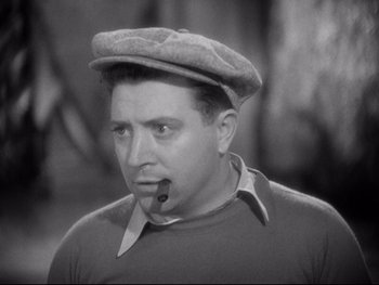 Movie still from “Footlight Parade” (1933), directed by Lloyd Bacon – A man with a pipe in his mouth wearing a hat; Close Up shot, Low angle