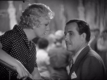 Movie still from “Footlight Parade” (1933), directed by Lloyd Bacon – An old photo of a man and a woman talking to each other; Close Up shot, Over the shoulder angle