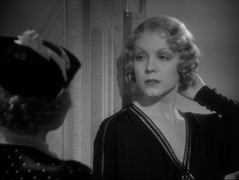 Movie still from “Footlight Parade” (1933), directed by Lloyd Bacon – An old photo of a woman putting on a hat in front of a mirror; Close Up shot, Over the shoulder angle