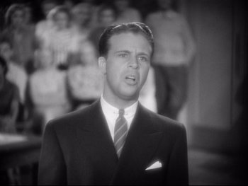 Movie still from “Footlight Parade” (1933), directed by Lloyd Bacon – A black and white photo of a man in a suit and tie; Close Up shot, High angle