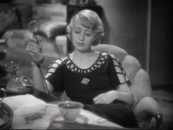 Movie still from “Footlight Parade” (1933), directed by Lloyd Bacon – A woman sitting at a table with a cup of coffee; Close Up shot, High angle