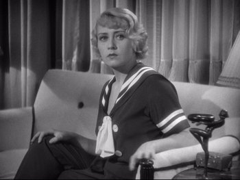 Movie still from “Footlight Parade” (1933), directed by Lloyd Bacon – A woman sitting on top of a couch holding a drink; Medium shot, High angle