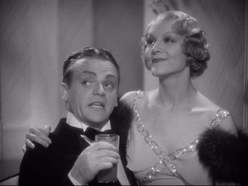 Movie still from “Footlight Parade” (1933), directed by Lloyd Bacon – An old photo of a man and a woman posing for a picture; Medium shot, Low angle