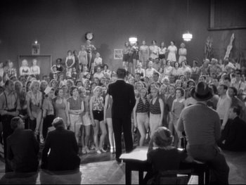 Movie still from “Footlight Parade” (1933), directed by Lloyd Bacon – A group of people standing in front of an audience; Extreme Wide shot, High angle