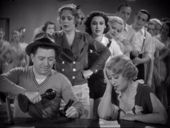 Movie still from “Footlight Parade” (1933), directed by Lloyd Bacon – An old photo of a group of people in a room; Medium shot, High angle