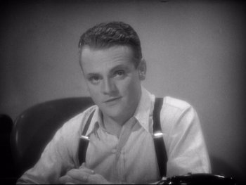 Movie still from “Footlight Parade” (1933), directed by Lloyd Bacon – A man sitting at a desk wearing suspenders; Close Up shot, High angle