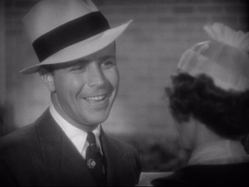 Movie still from “Footlight Parade” (1933), directed by Lloyd Bacon – A man wearing a hat and a suit smiling for the camera; Close Up shot, Low angle