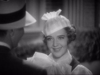 Movie still from “Footlight Parade” (1933), directed by Lloyd Bacon – A woman wearing a white hat and a white dress; Close Up shot, Over the shoulder angle