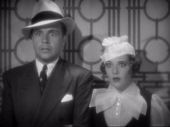 Movie still from “Footlight Parade” (1933), directed by Lloyd Bacon – A man and a woman standing next to each other in front of a wall; Medium shot, Low angle
