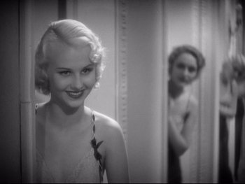 Movie still from “Footlight Parade” (1933), directed by Lloyd Bacon – A young woman standing in front of a bathroom mirror; Close Up shot, Over the shoulder angle