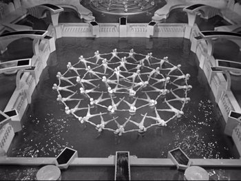 Movie still from “Footlight Parade” (1933), directed by Lloyd Bacon – A group of people standing on top of each other in a circle; Extreme Wide shot, High angle
