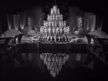 Movie still from “Footlight Parade” (1933), directed by Lloyd Bacon – A black - and - white photo of a fountain in the shape of a pyramid; Extreme Wide shot, High angle