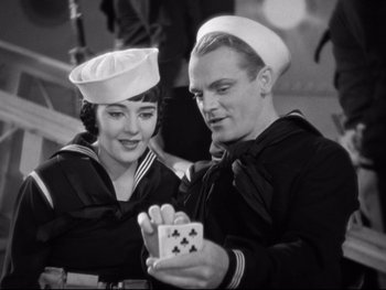 Movie still from “Footlight Parade” (1933), directed by Lloyd Bacon – A man and a woman in sailor uniforms holding a card; Medium shot, High angle