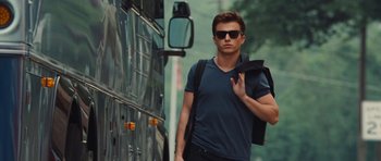 Movie still from “Footloose” (2011), directed by Craig Brewer – A young man walking down the street in front of a bus; Medium shot, Low angle