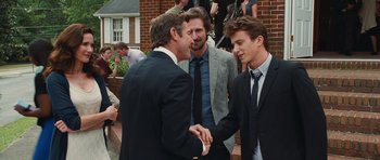 Movie still from “Footloose” (2011), directed by Craig Brewer – A group of men standing next to each other on a sidewalk; Medium shot, Over the shoulder angle
