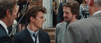 Movie still from “Footloose” (2011), directed by Craig Brewer – Two men in suits talking to each other outside a building; Close Up shot, Over the shoulder angle
