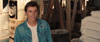 Movie still from “Footloose” (2011), directed by Craig Brewer – A man in a jean jacket standing next to a pile of wood; Close Up shot, Over the shoulder angle