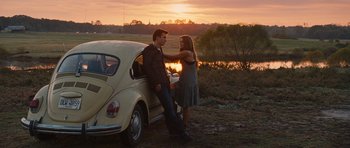 Movie still from “Footloose” (2011), directed by Craig Brewer – A man and a woman standing next to a car; Wide shot, Over the shoulder angle