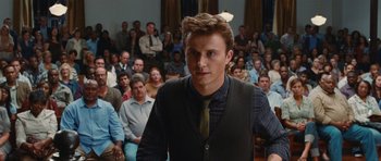 Movie still from “Footloose” (2011), directed by Craig Brewer – A man standing in front of a crowd of people; Medium shot, Over the shoulder angle