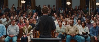Movie still from “Footloose” (2011), directed by Craig Brewer – A crowd of people sitting and standing in front of a microphone; Wide shot, Over the shoulder angle