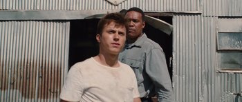Movie still from “Footloose” (2011), directed by Craig Brewer – Two men standing next to each other in front of a building; Close Up shot, Over the shoulder angle
