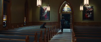 Movie still from “Footloose” (2011), directed by Craig Brewer – A man sitting in a pew in front of a stained glass window in a church; Wide shot, Over the shoulder angle