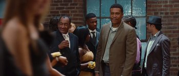 Movie still from “Footloose” (2011), directed by Craig Brewer – A group of men standing next to each other in suits; Medium shot, Over the shoulder angle