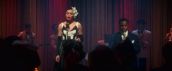 Movie still from “The United States vs. Billie Holiday” (2021), directed by Lee Daniels – A woman standing in front of a microphone on a stage; Medium shot, High angle