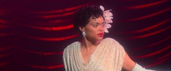 Movie still from “The United States vs. Billie Holiday” (2021), directed by Lee Daniels – A woman in a white dress with a flower in her hair; Close Up shot, Over the shoulder angle