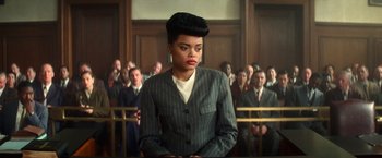 Movie still from “The United States vs. Billie Holiday” (2021), directed by Lee Daniels – A woman in a suit stands in front of a group of people; Close Up shot, Low angle