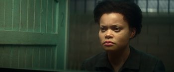 Movie still from “The United States vs. Billie Holiday” (2021), directed by Lee Daniels – A woman looking out of a window in a dark room; Close Up shot, High angle