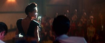 Movie still from “The United States vs. Billie Holiday” (2021), directed by Lee Daniels – A woman standing on a stage holding a microphone; Medium shot, Over the shoulder angle