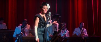Movie still from “The United States vs. Billie Holiday” (2021), directed by Lee Daniels – A woman singing into a microphone in front of a band; Medium shot, Low angle