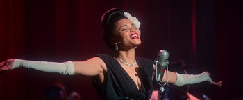 Movie still from “The United States vs. Billie Holiday” (2021), directed by Lee Daniels – A woman in a black dress singing into a microphone; Close Up shot, Low angle