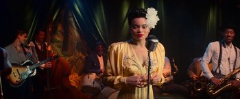 Movie still from “The United States vs. Billie Holiday” (2021), directed by Lee Daniels – A woman holding a microphone in front of a man; Medium shot, Over the shoulder angle