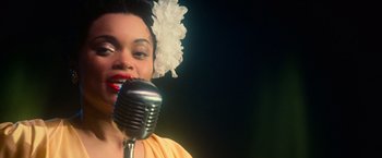 Movie still from “The United States vs. Billie Holiday” (2021), directed by Lee Daniels – A person singing on a microphone; Close Up shot, Low angle