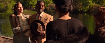 Movie still from “The United States vs. Billie Holiday” (2021), directed by Lee Daniels – A man in a suit holding a hat in front of a woman; Medium shot, Over the shoulder angle