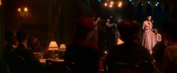 Movie still from “The United States vs. Billie Holiday” (2021), directed by Lee Daniels – A group of people sitting in front of a microphone; Extreme Wide shot, Over the shoulder angle