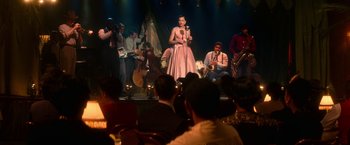 Movie still from “The United States vs. Billie Holiday” (2021), directed by Lee Daniels – A group of people on a stage with a woman singing into a microphone; Wide shot, Over the shoulder angle