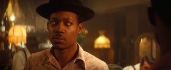 Movie still from “The United States vs. Billie Holiday” (2021), directed by Lee Daniels – A person wearing a hat; Close Up shot, Over the shoulder angle
