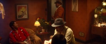 Movie still from “The United States vs. Billie Holiday” (2021), directed by Lee Daniels – A group of people sitting around a table; Medium shot, Over the shoulder angle