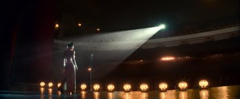 Movie still from “The United States vs. Billie Holiday” (2021), directed by Lee Daniels – A woman standing on a stage in front of a microphone; Wide shot, Low angle