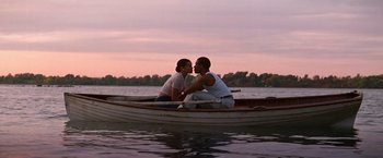 Movie still from “The United States vs. Billie Holiday” (2021), directed by Lee Daniels – A man and a woman sitting in a row boat kissing; Wide shot, Low angle