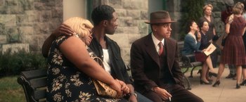 Movie still from “The United States vs. Billie Holiday” (2021), directed by Lee Daniels – A group of people sitting next to each other on a bench; Medium shot, Over the shoulder angle