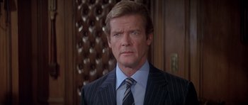 Movie still from “For Your Eyes Only” (1981), directed by John Glen – A person wearing a suit and tie; Close Up shot, Over the shoulder angle