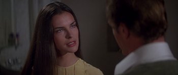 Movie still from “For Your Eyes Only” (1981), directed by John Glen – A woman in a yellow shirt is talking to a man in a white shirt; Close Up shot, Over the shoulder angle