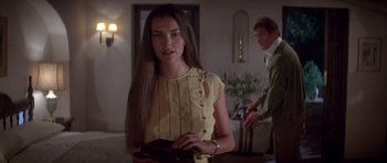 Movie still from “For Your Eyes Only” (1981), directed by John Glen – A woman with long brown hair standing in front of a man; Close Up shot, Over the shoulder angle