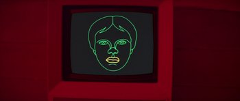 Movie still from “For Your Eyes Only” (1981), directed by John Glen – A television screen with a neon face on it; Close Up shot, Overhead angle