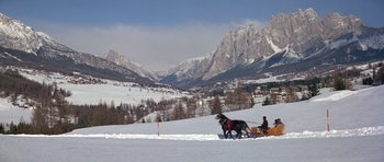 Movie still from “For Your Eyes Only” (1981), directed by John Glen – A man riding a horse drawn carriage across a snow covered field; Extreme Wide shot, High angle
